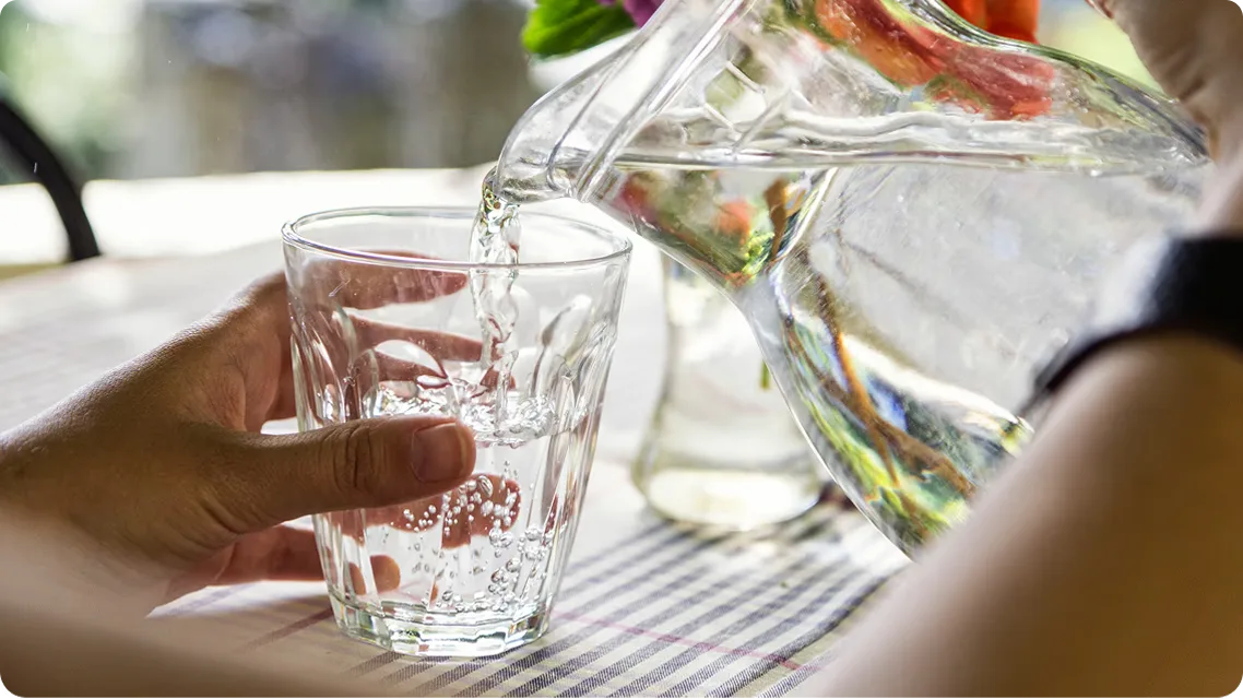 Water being poured from a pitcher into a glass