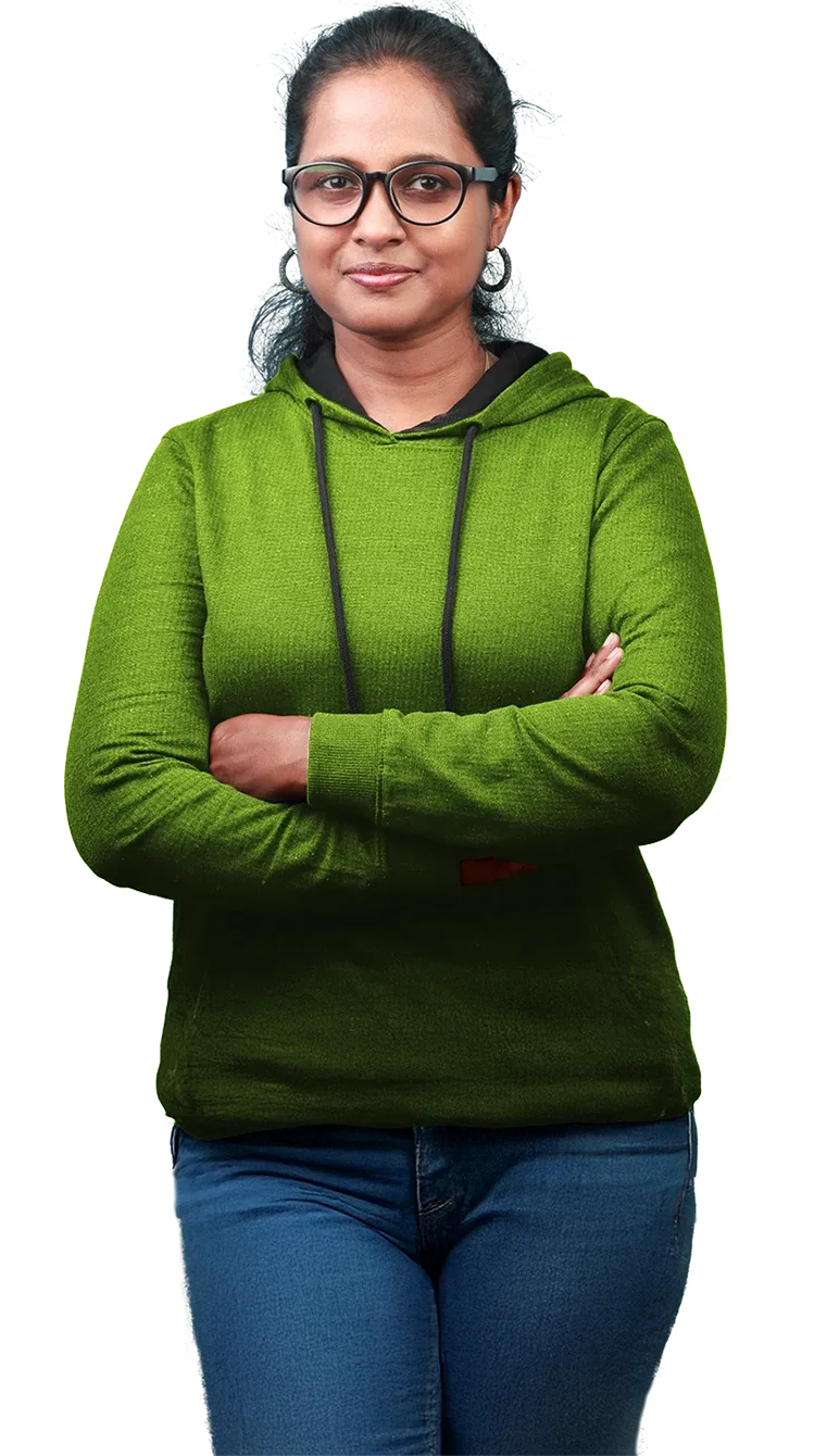 Woman in a green jumper and blue jeans, standing confidently, with arms crossed.