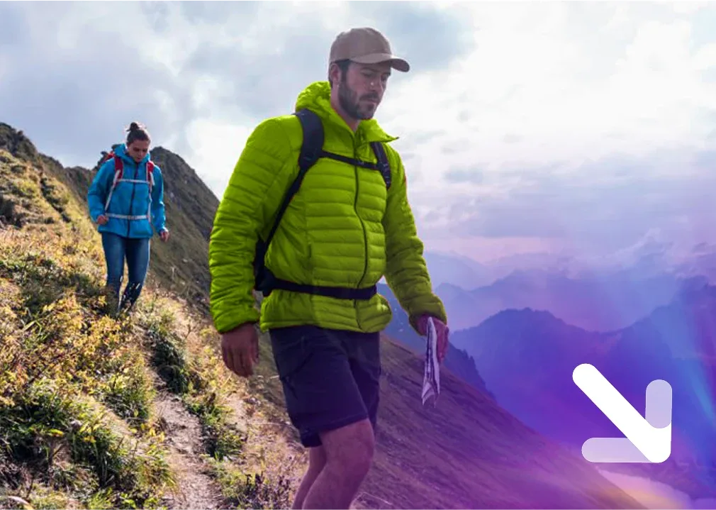 Two hikers trekking downward on a mountain trail with backpacks and a map, with purple gradient and arrow pointing down.